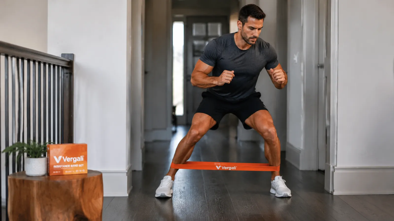 Person walking laterally in a banded monster walk exercise across a wood floor