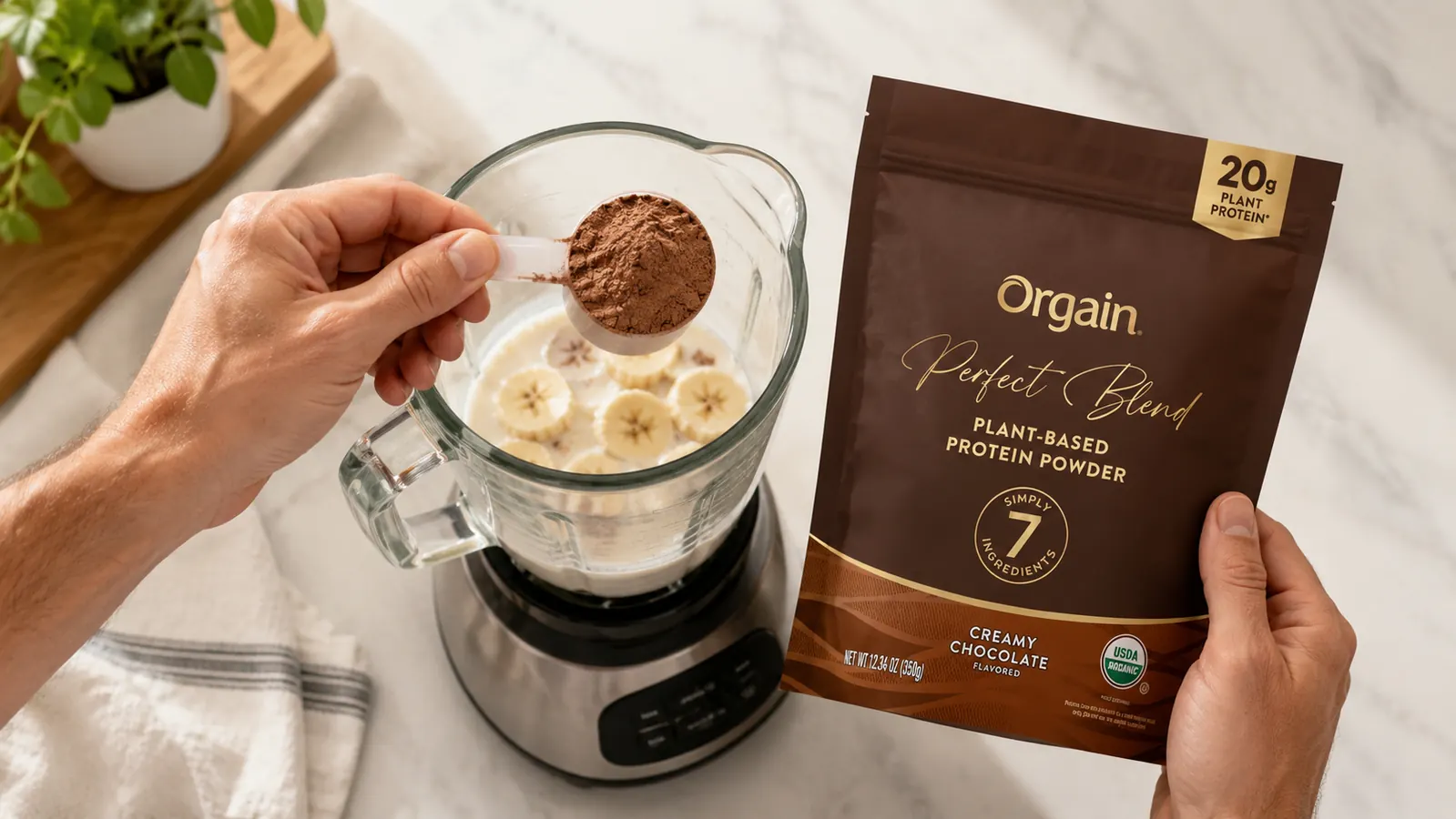 Scoop of brown plant protein powder being poured into a blender with almond milk and banana