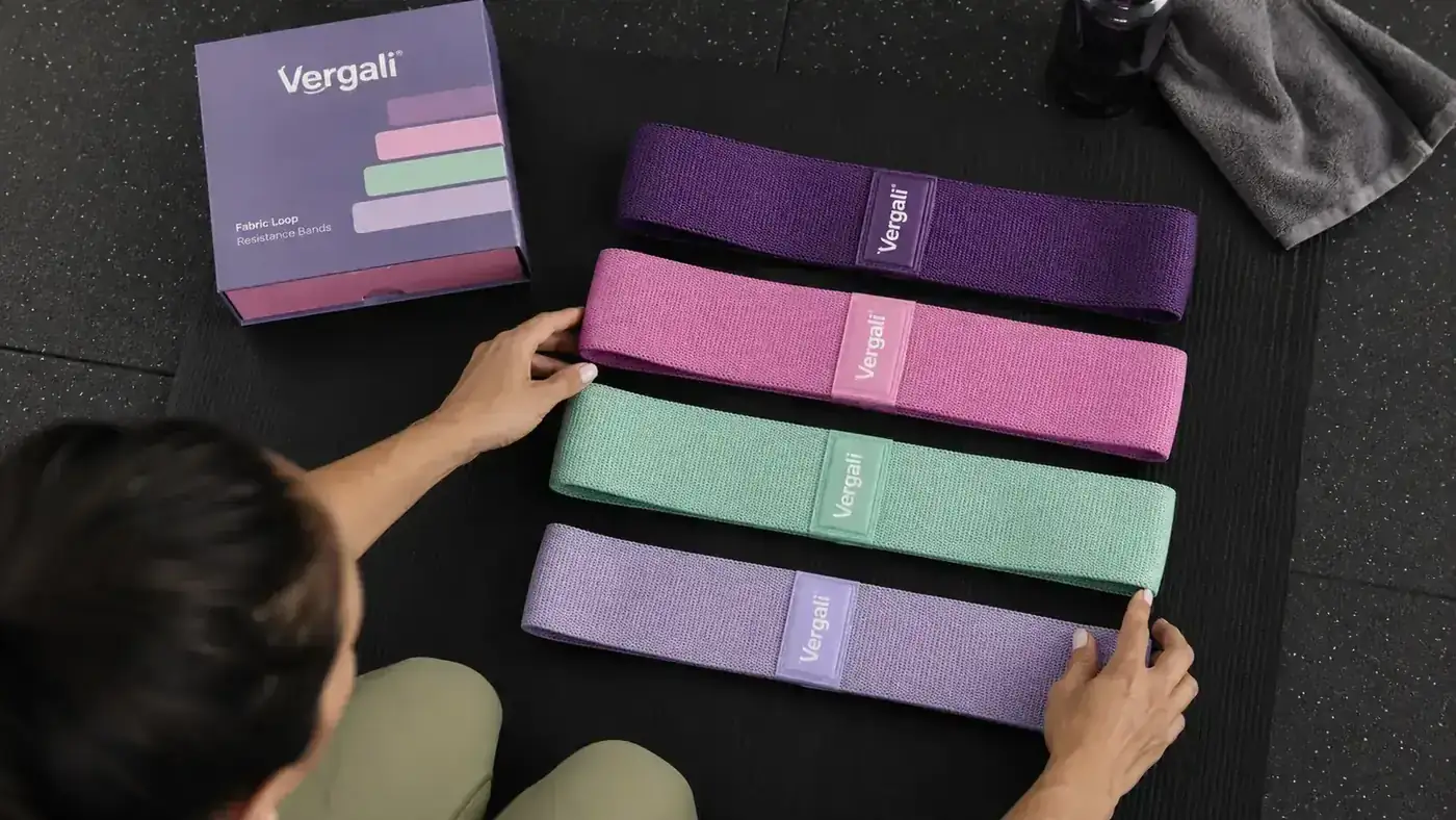 Close-up of a set of four Vergali resistance bands laid out in order of resistance on a gym mat
