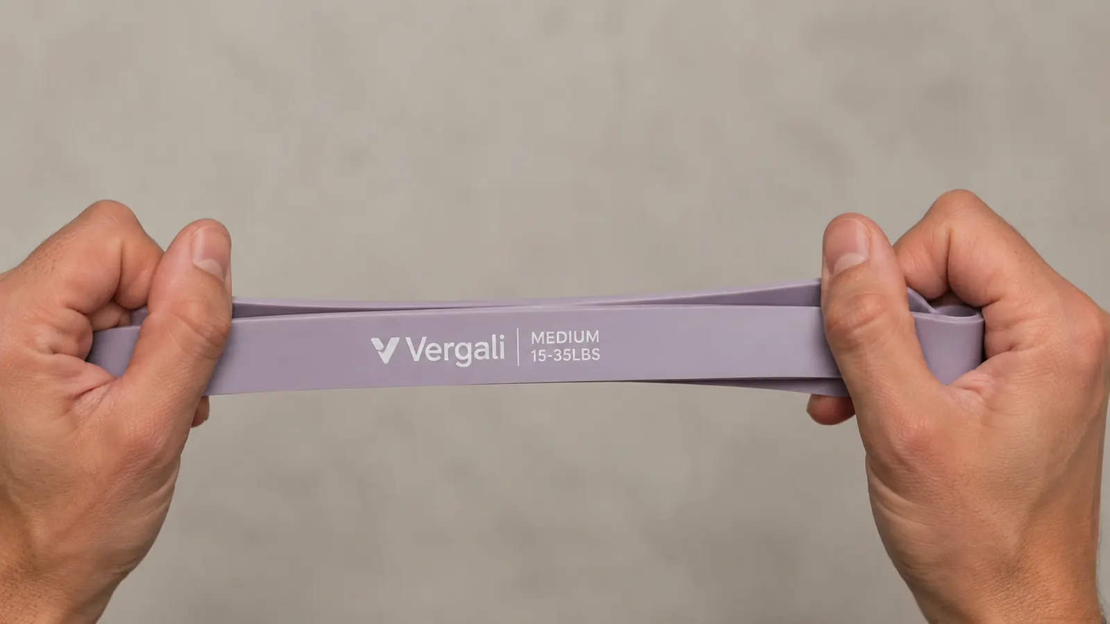 Person holding a Vergali resistance band at arm's length showing the band thickness and texture