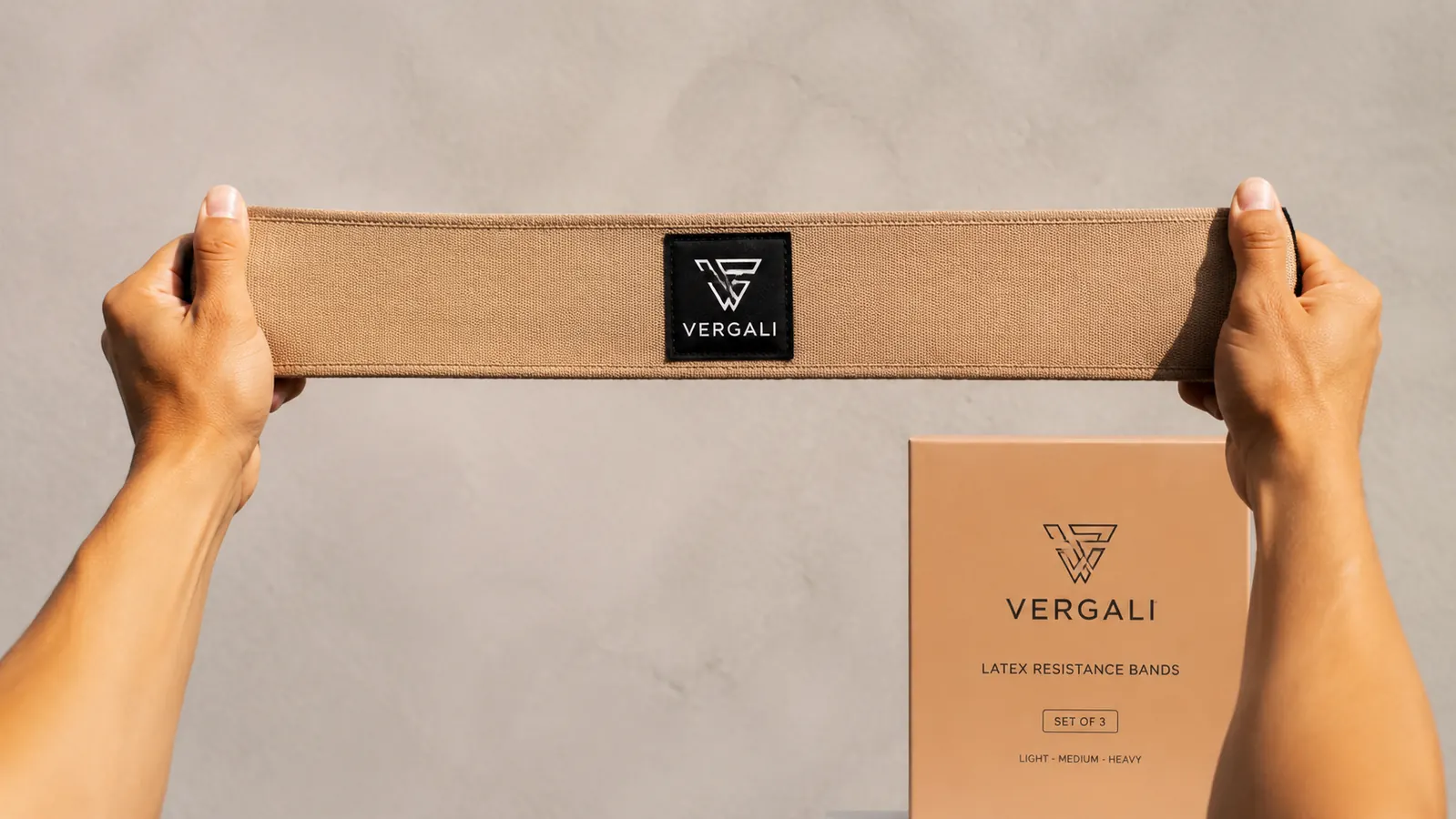Close-up of Vergali resistance band being stretched between two hands, showing the latex texture